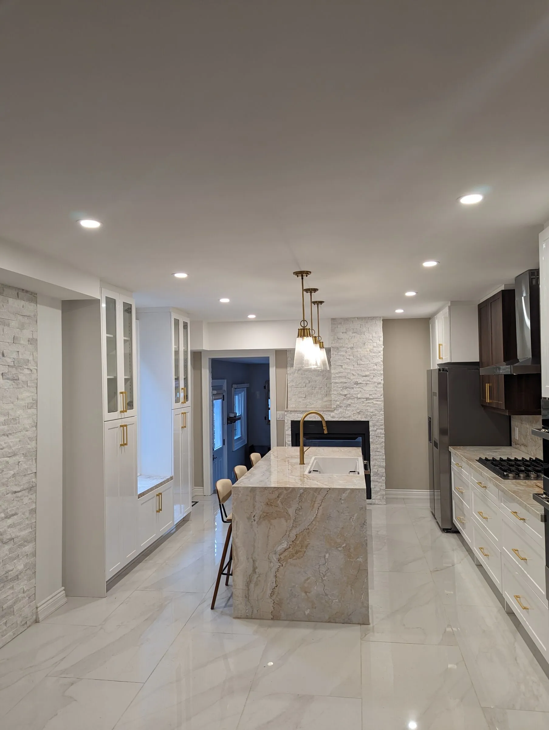 Kitchen renovation in Scarborough by EH Contracting: white cabinets, marble waterfall island, pendant lights